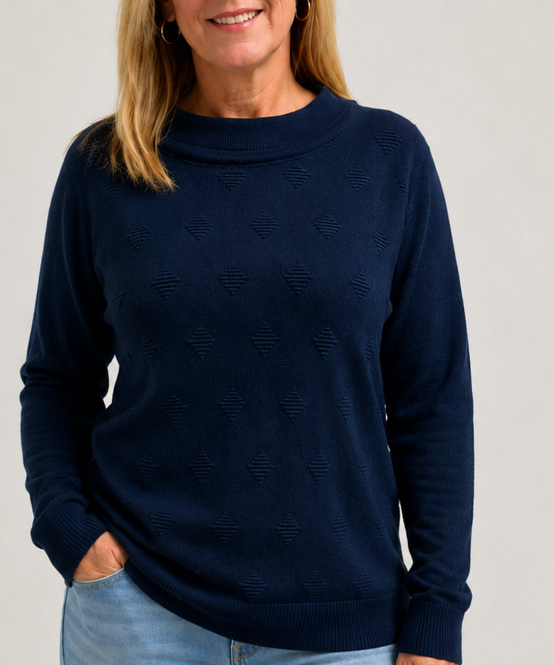 Woman wearing a navy blue jumper with a subtle pattern on a light gray background