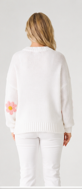 white knit jumper with a pink flower design on a plain back