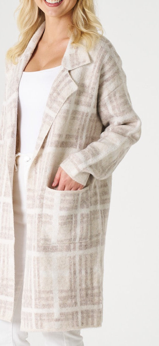 Woman wearing a long, light-colored plaid coat on a white background