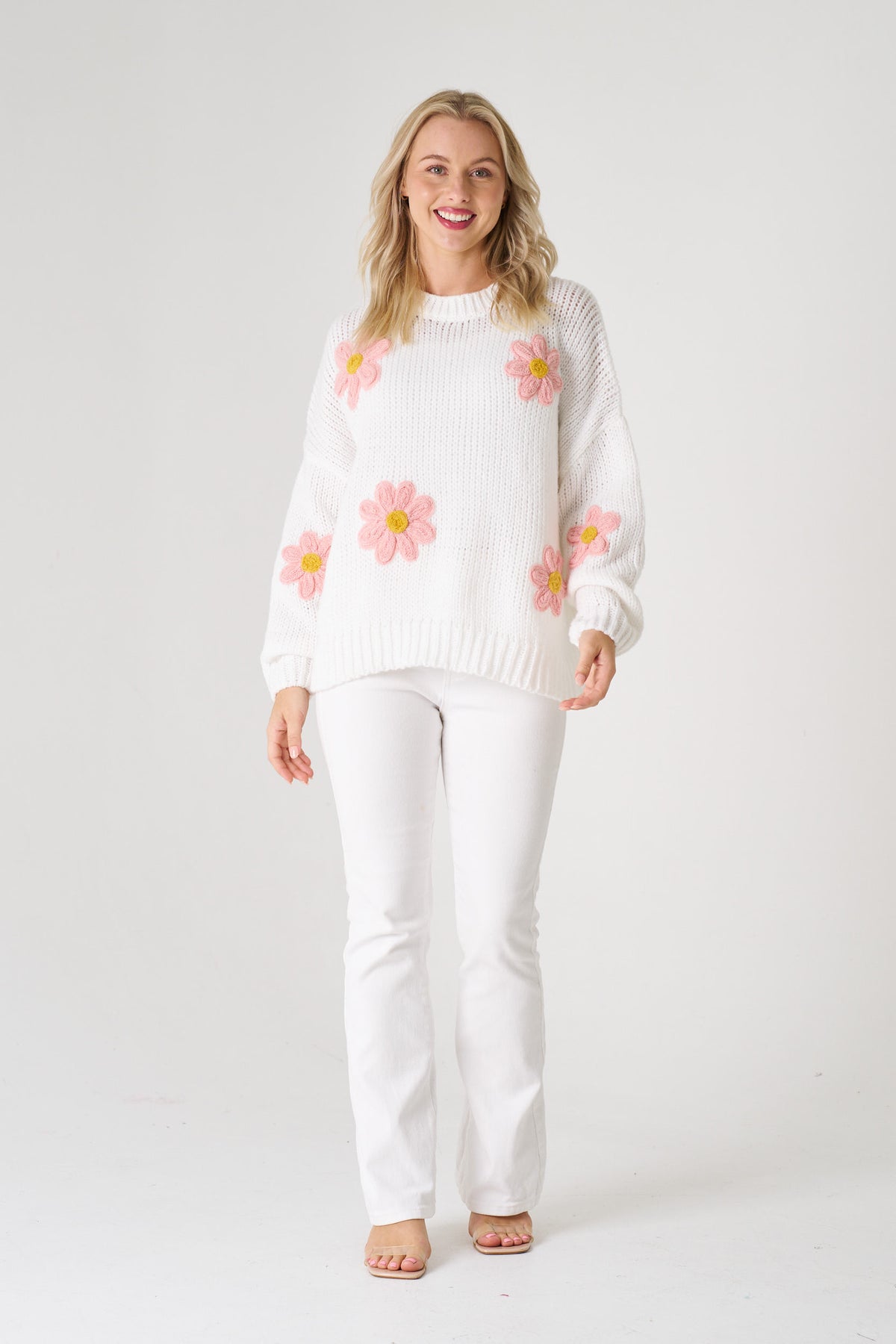 white sweater with pink floral patterns on a white background