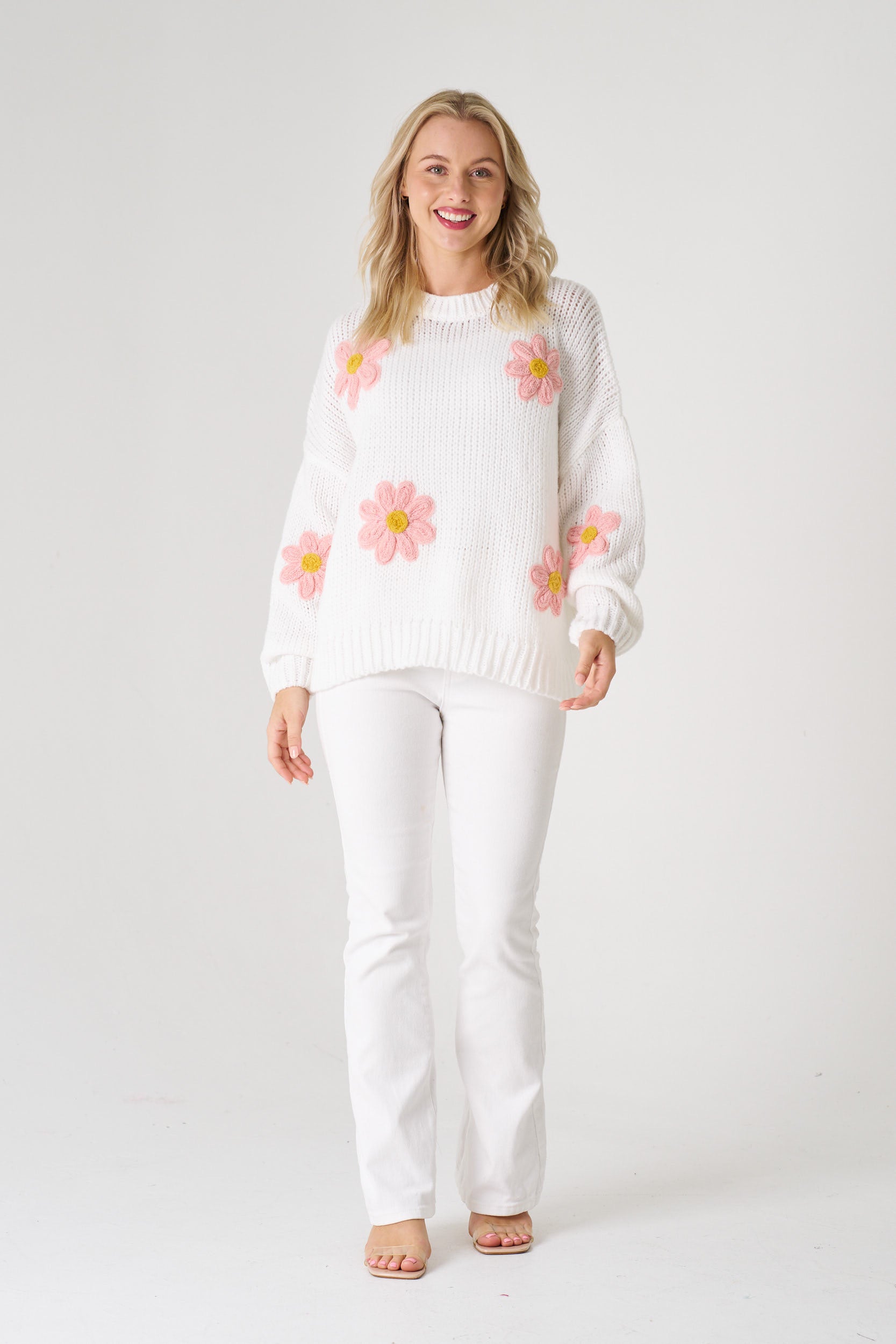  white sweater with pink floral patterns on a white background