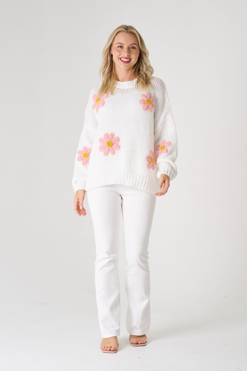  white sweater with pink floral patterns on a white background