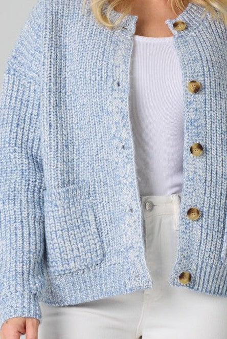 Light blue textured cardigan with brown buttons .